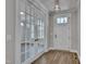 Spacious entryway featuring french doors to the left, white front door, wood floors, and elegant light fixture at , Chapel Hill, NC 27516