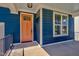 Inviting front porch showcasing the blue wood facade, contrasting orange door, and a large window with white trim at , Chapel Hill, NC 27516