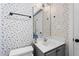 Cozy bathroom featuring floral wallpaper, an elegant mirror, and a gray vanity at 140 Heatherwood Dr, Apex, NC 27502