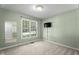 A cozy room with a window view and a wall-mounted TV at 140 Heatherwood Dr, Apex, NC 27502