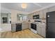 Bright kitchen features painted cabinets, stainless steel appliances, and an open floorplan at 140 Heatherwood Dr, Apex, NC 27502