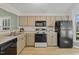Functional kitchen with painted cabinets, modern appliances, and laminate countertops at 140 Heatherwood Dr, Apex, NC 27502