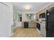 Well-lit kitchen featuring a passthrough, painted cabinets, and modern appliances at 140 Heatherwood Dr, Apex, NC 27502