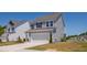 Side view of a modern two-story home with a two-car garage, lawn, and a concrete driveway at 147 Antler Steel Dr, Clayton, NC 27527