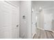 Hallway with multiple doors and modern flooring; thermostat and light switches visible at 147 Antler Steel Dr, Clayton, NC 27527