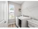 Well-lit laundry room featuring modern washer, dryer, utility sink and shelving at 147 Antler Steel Dr, Clayton, NC 27527