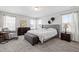 Large main bedroom with a queen sized bed, dresser and soft, natural light from multiple windows at 147 Antler Steel Dr, Clayton, NC 27527