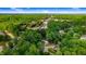 Aerial view showcases home in wooded neighborhood with nearby roadways and other homes at 1609 Falls Ct, Raleigh, NC 27615