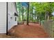View of the backyard with a wooden deck, tall trees, and a wooden fence at 1609 Falls Ct, Raleigh, NC 27615