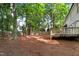Expansive backyard with mature trees, wooden fence, and a deck, offering a private outdoor space at 1609 Falls Ct, Raleigh, NC 27615