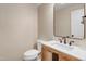 Modern half bath with a wood vanity and a sleek mirror, adding a touch of elegance at 1609 Falls Ct, Raleigh, NC 27615