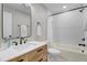 Bathroom featuring wood vanity, updated fixtures, and white tiled shower and tub at 1609 Falls Ct, Raleigh, NC 27615