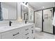 Bathroom with double vanity, black hardware, and glass-enclosed shower at 1609 Falls Ct, Raleigh, NC 27615