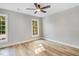 Spacious bedroom with hardwood floors, neutral walls, ceiling fan, and sun-filled windows at 1609 Falls Ct, Raleigh, NC 27615