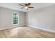 This bedroom offers wood-look flooring, ceiling fan, and a double-hung window at 1609 Falls Ct, Raleigh, NC 27615
