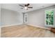 Spacious bedroom featuring wood-look flooring, ceiling fan, and double-hung windows at 1609 Falls Ct, Raleigh, NC 27615