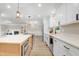 A kitchen featuring white cabinets, quartz countertops, and stainless-steel appliances at 1609 Falls Ct, Raleigh, NC 27615