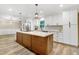 Bright kitchen with stainless steel appliances, a large island, and modern lighting fixtures at 1609 Falls Ct, Raleigh, NC 27615