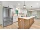 Modern kitchen with stainless steel refrigerator, island with a cooktop and seating at 1609 Falls Ct, Raleigh, NC 27615