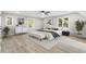 A beautifully staged main bedroom with light gray walls, light floors, and three bright windows at 1609 Falls Ct, Raleigh, NC 27615