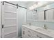 Modern bathroom featuring double sinks, a sliding barn door, and modern finishes at 1623 Village Glenn Dr, Raleigh, NC 27612