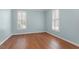 This bedroom features hardwood floors, a neutral color scheme, and windows with shutter-style coverings at 1623 Village Glenn Dr, Raleigh, NC 27612