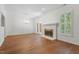 Open-concept living room with hardwood floors, bright lighting, a fireplace and stylish chandelier at 1623 Village Glenn Dr, Raleigh, NC 27612