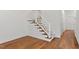 Carpeted staircase with white, decorative railing located in a well-lit room with hardwood floors at 1623 Village Glenn Dr, Raleigh, NC 27612