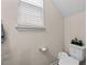Bright bathroom includes white toilet, a window, and neutral wall color at 1839 Huntley Way, Burlington, NC 27215
