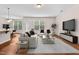 Bright living room featuring modern furniture, a large TV, and hardwood floors, offering a cozy and inviting atmosphere at 1839 Huntley Way, Burlington, NC 27215