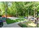 Aerial view of backyard featuring basketball court, patio with seating, storage, and luscious landscape at 2029 Atkins Dr, Raleigh, NC 27610