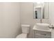 Bathroom with white walls, white sink, a large mirror, and white toilet at 2029 Atkins Dr, Raleigh, NC 27610
