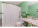 Bathroom featuring green walls, shower with white curtain, toilet, vanity, and shelves at 2029 Atkins Dr, Raleigh, NC 27610