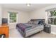 Bedroom with a large bed, plaid blanket, grey sheets, two windows, and side tables at 2029 Atkins Dr, Raleigh, NC 27610