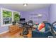 Bedroom with hardwood floors, purple walls, blue couch, desk, and natural light at 2029 Atkins Dr, Raleigh, NC 27610
