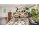 Bright dining area with a wood table set for four, complemented by an eclectic assortment of potted plants at 2029 Atkins Dr, Raleigh, NC 27610