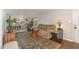 Inviting living room with cozy seating, dark wood floors, and an open view into a dining area filled with plants at 2029 Atkins Dr, Raleigh, NC 27610