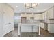 Modern kitchen with gray wood floors, white cabinets, granite countertops, and a large island at 246 Pretty Run Branch Ln, Wendell, NC 27591