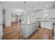 Open kitchen with hardwood floors, white cabinets, granite countertops, stainless steel appliances, and kitchen island at 246 Pretty Run Branch Ln, Wendell, NC 27591