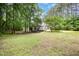 Spacious backyard with mature trees and home's exterior and deck visible at 25 Williamston Ridge Dr, Youngsville, NC 27596
