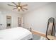 Bright bedroom with wood flooring, ceiling fan, neutral paint, and metal bed frame with updated furnishings at 25 Williamston Ridge Dr, Youngsville, NC 27596