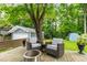 Cozy backyard deck featuring patio seating, a fire pit, and a lush green space with mature trees at 2517 Medway Dr, Raleigh, NC 27608