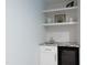 Compact bar area with sink, shelving and under-counter refrigerator at 2517 Medway Dr, Raleigh, NC 27608