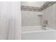 Modern bathroom features white tile with a decorative accent strip and chrome fixtures at 2517 Medway Dr, Raleigh, NC 27608