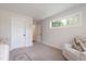 Bright bedroom featuring a white door, window and comfortable recliner at 2517 Medway Dr, Raleigh, NC 27608