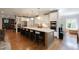 Open kitchen design features an expansive island with seating, stainless steel appliances, and hardwood floors at 2517 Medway Dr, Raleigh, NC 27608