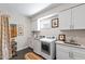 A bright laundry room features white cabinets, modern machines, and ample counter space at 2517 Medway Dr, Raleigh, NC 27608