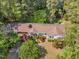 Aerial view of the home with a landscaped yard surrounded by lush trees in a wooded neighborhood at 2608 Knightwood Rd, Fuquay Varina, NC 27526
