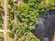 Overhead view of a house nestled among green trees, adjacent to a serene lake at 2608 Knightwood Rd, Fuquay Varina, NC 27526