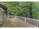 Large wooden back deck with white railing overlooking wooded backyard at 2608 Knightwood Rd, Fuquay Varina, NC 27526
